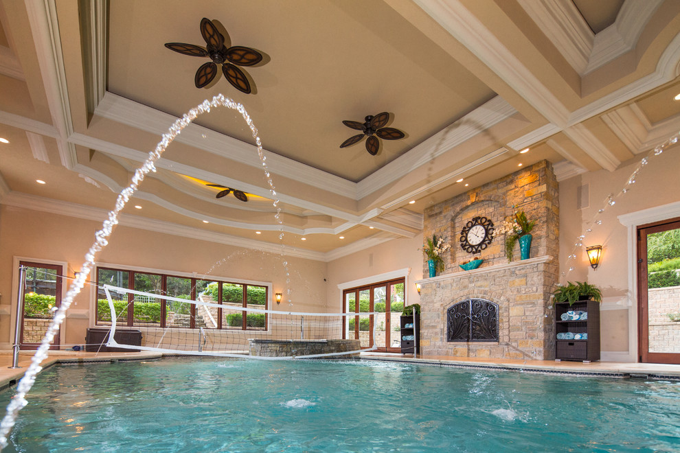 Expansive tropical indoor rectangular pool in Chicago with a water feature and natural stone pavers.