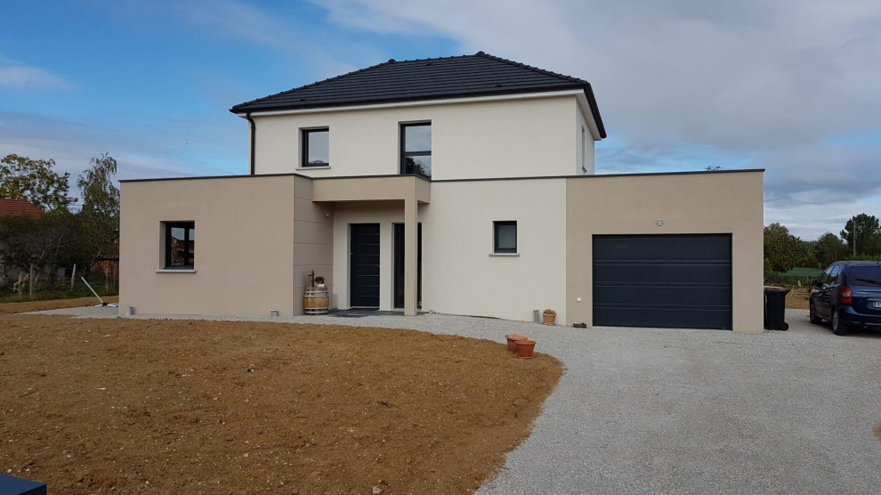 Large modern two-storey concrete beige house exterior in Dijon with a flat roof.
