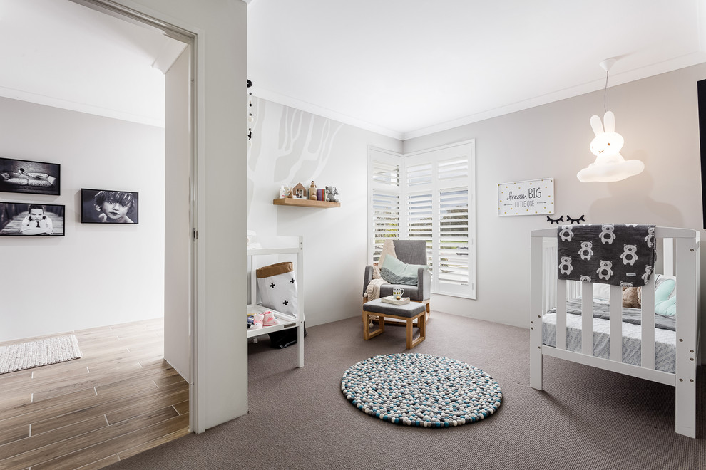 Imagen de habitación de bebé neutra actual pequeña con paredes grises, moqueta y suelo gris