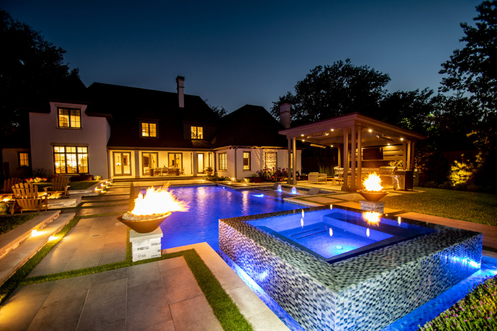 Diseño de piscina alargada clásica renovada grande a medida en patio trasero con suelo de baldosas