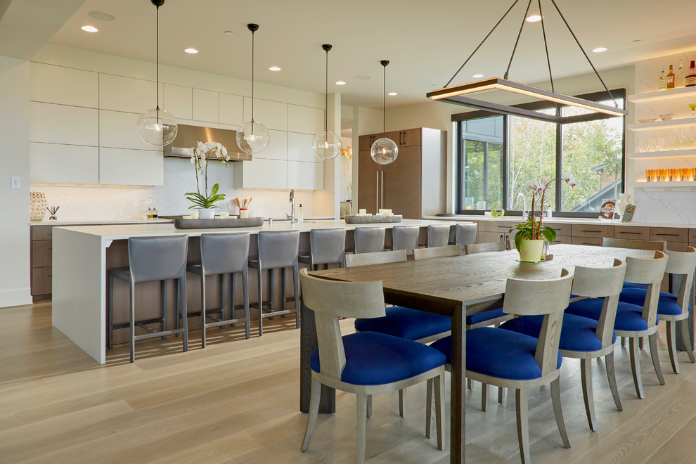 Inspiration for a large contemporary eat-in kitchen in Seattle with flat-panel cabinets, white cabinets, quartz benchtops, white splashback, light hardwood floors, with island and white benchtop.