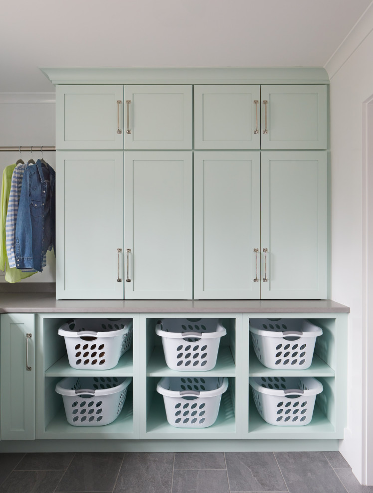Large transitional u-shaped dedicated laundry room in Boston with an undermount sink, turquoise cabinets, quartz benchtops, white walls, ceramic floors, a stacked washer and dryer, grey floor and grey benchtop.