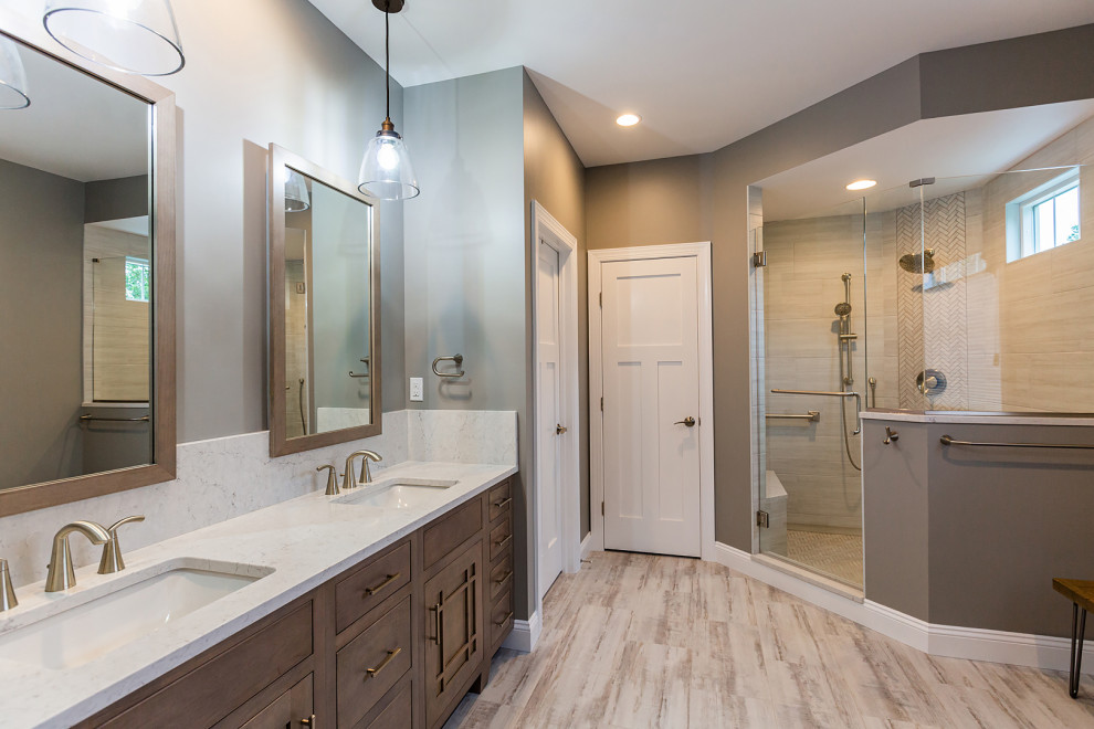 This is an example of a large modern master bathroom in Other with flat-panel cabinets, medium wood cabinets, a corner shower, a two-piece toilet, white tile, stone slab, brown walls, wood-look tile, an undermount sink, quartzite benchtops, multi-coloured floor, a hinged shower door, white benchtops, a shower seat, a double vanity and a built-in vanity.