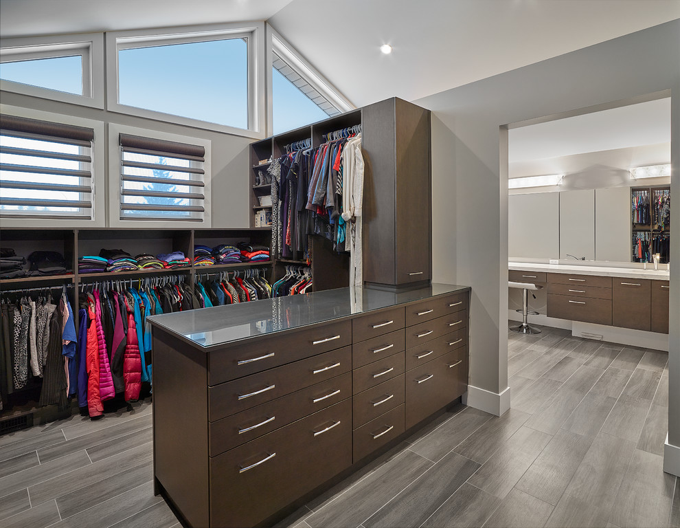 Inspiration for a mid-sized modern men's walk-in wardrobe in Calgary with medium wood cabinets.