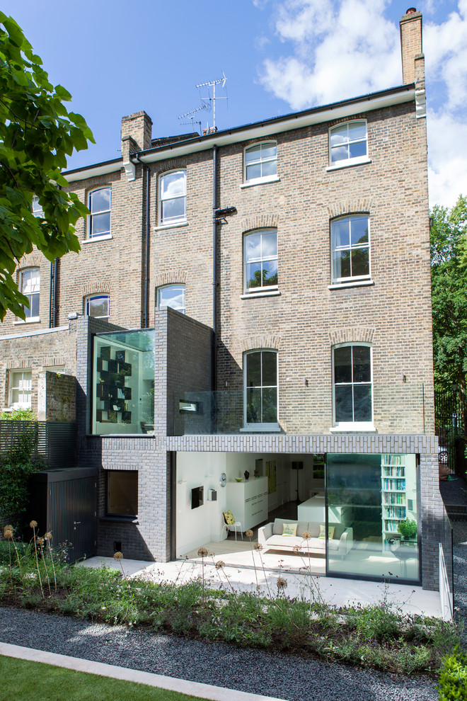 This is an example of a large contemporary three-storey brick beige exterior in London.