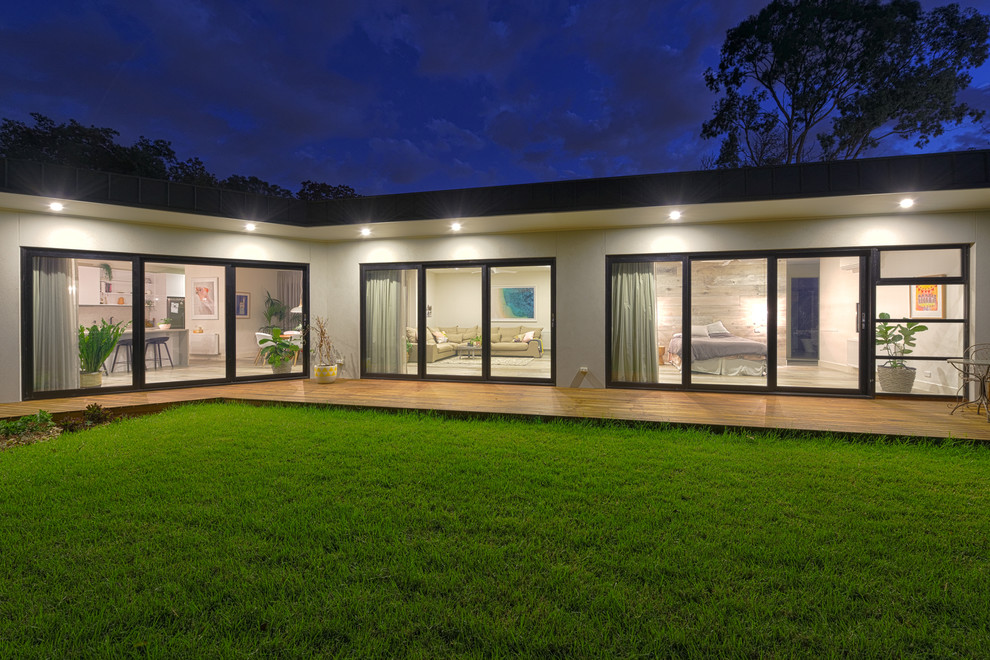 Large contemporary one-storey grey house exterior in Melbourne with a flat roof and a metal roof.