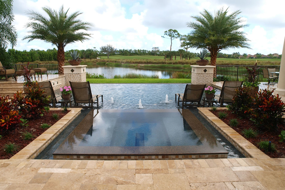 Photo of a mid-sized traditional backyard custom-shaped lap pool in Miami with a hot tub and tile.