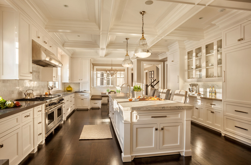 Inspiration for a large transitional u-shaped kitchen in New York with a farmhouse sink, shaker cabinets, white cabinets, marble benchtops, white splashback, porcelain splashback, stainless steel appliances, dark hardwood floors and with island.