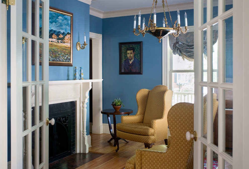 Design ideas for a mid-sized traditional formal open concept living room in Boston with blue walls, medium hardwood floors, no tv and a standard fireplace.