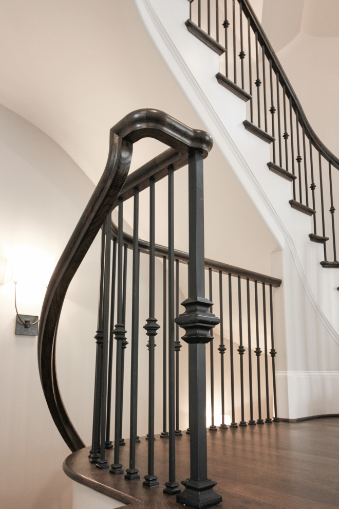 Aménagement d'un grand escalier peint flottant classique avec des marches en bois et un garde-corps en métal.