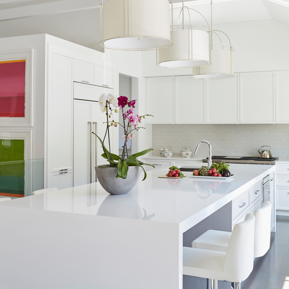 Transitional kitchen in Chicago with white splashback, stainless steel appliances, with island and exposed beam.