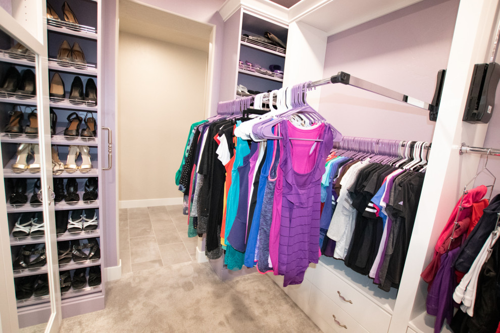 Diseño de armario vestidor de mujer moderno grande con armarios con paneles lisos, puertas de armario blancas, moqueta, suelo violeta y casetón