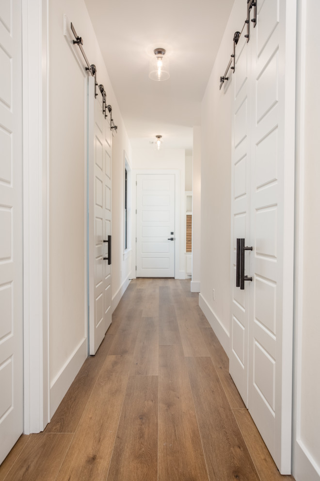 Источник вдохновения для домашнего уюта: большой коридор в стиле кантри с белыми стенами, полом из винила и коричневым полом