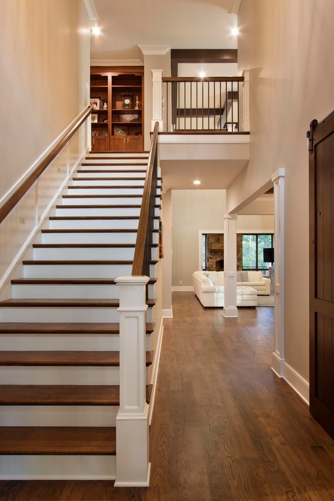 Inspiration for a large transitional wood straight staircase in Other with painted wood risers and metal railing.
