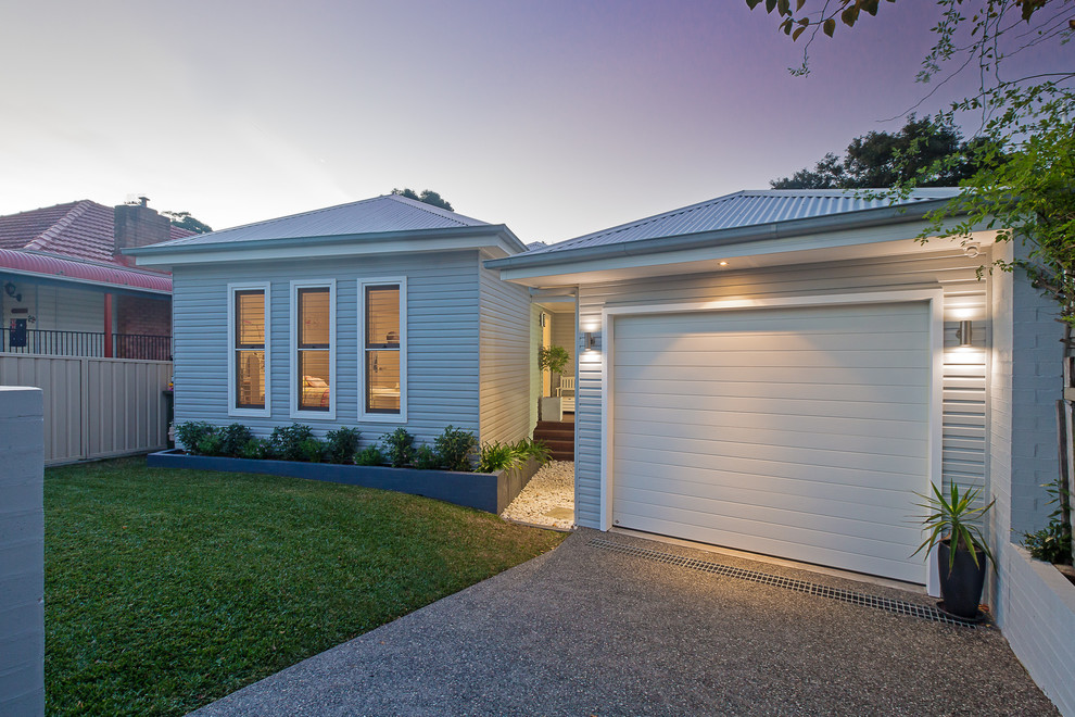 Design ideas for a mid-sized contemporary one-storey grey exterior in Newcastle - Maitland with wood siding, a shed roof and a metal roof.