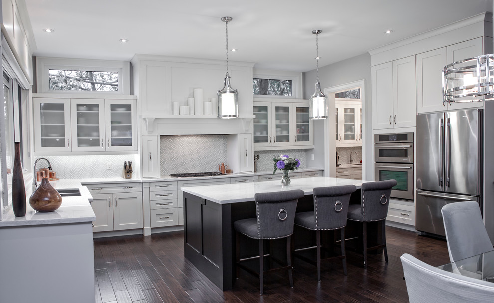 Inspiration for a large transitional u-shaped eat-in kitchen in Toronto with an undermount sink, shaker cabinets, white cabinets, marble benchtops, white splashback, glass tile splashback, stainless steel appliances, dark hardwood floors and with island.