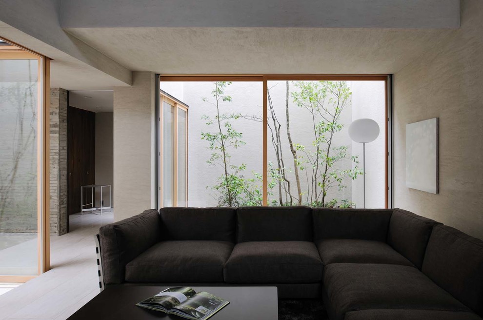 This is an example of a contemporary living room in Osaka with beige walls and a freestanding tv.