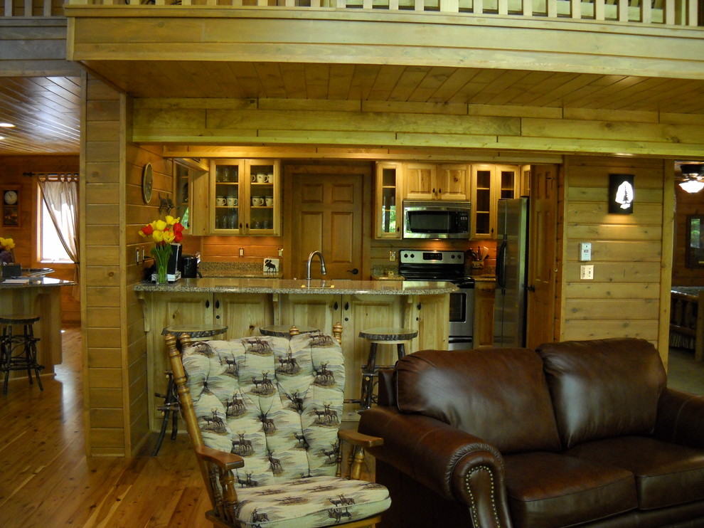 Open concept kitchen - mid-sized rustic u-shaped medium tone wood floor and brown floor open concept kitchen idea with glass-front cabinets, light wood cabinets, granite countertops, brown backsplash, wood backsplash, stainless steel appliances and an island