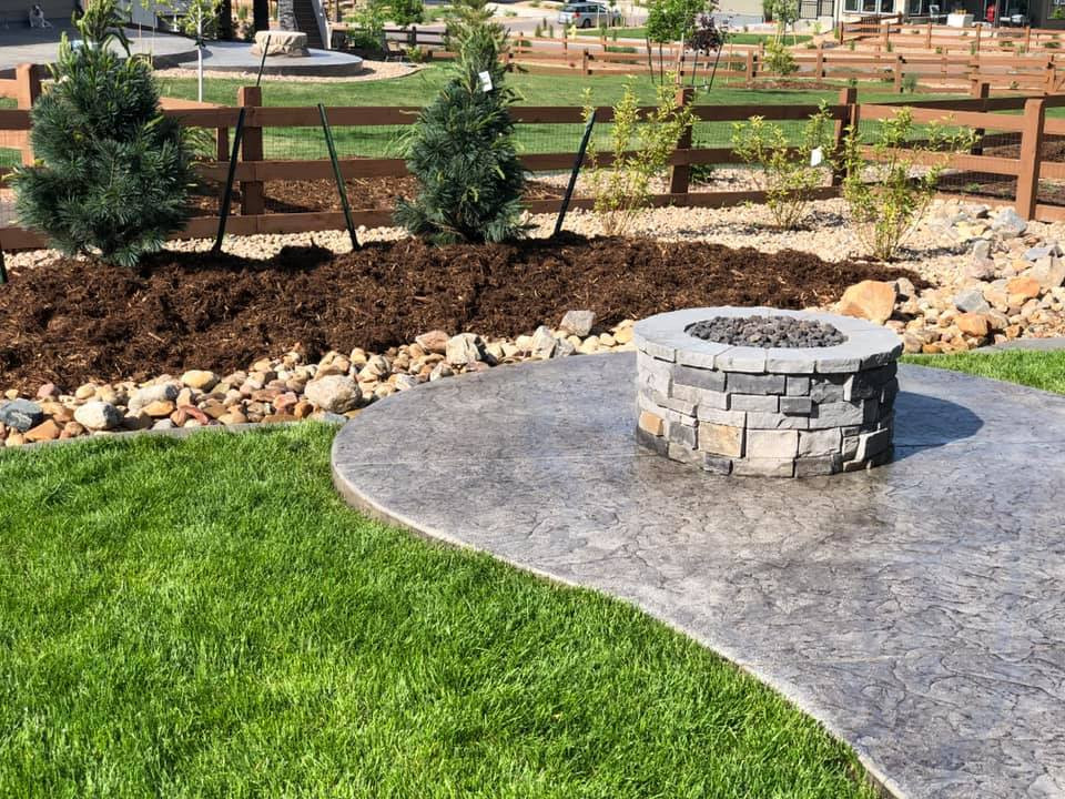 Large traditional backyard full sun xeriscape in Denver with a fire feature, river rock and a wood fence.