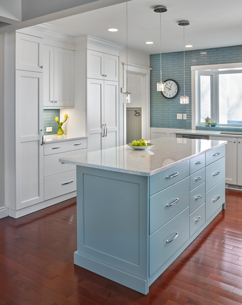 Kitchen - mid-sized transitional l-shaped medium tone wood floor kitchen idea in Edmonton with an undermount sink, recessed-panel cabinets, white cabinets, quartz countertops, blue backsplash, glass tile backsplash, stainless steel appliances and an island