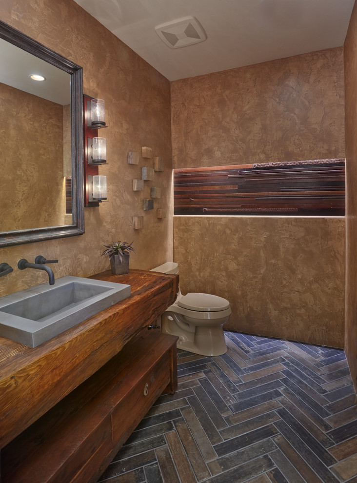 Inspiration for a powder room in Phoenix with furniture-like cabinets, medium wood cabinets, brown walls, a drop-in sink, wood benchtops, brown floor and brown benchtops.
