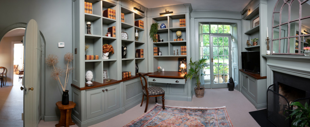 Exemple d'un bureau chic de taille moyenne avec un mur gris, moquette, une cheminée standard, un manteau de cheminée en plâtre, un bureau intégré, un sol beige, un plafond en papier peint et du papier peint.