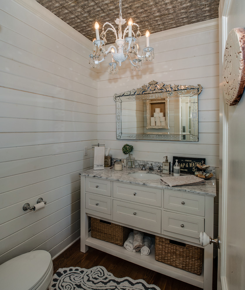 Inspiration for a mid-sized traditional powder room in Wilmington with beaded inset cabinets, white cabinets, a one-piece toilet, white walls, medium hardwood floors, an undermount sink, engineered quartz benchtops and grey benchtops.