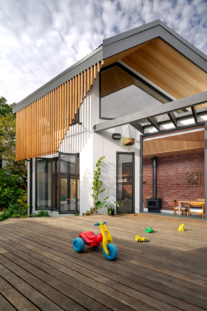 This is an example of a mid-sized contemporary backyard deck in Melbourne with an awning.