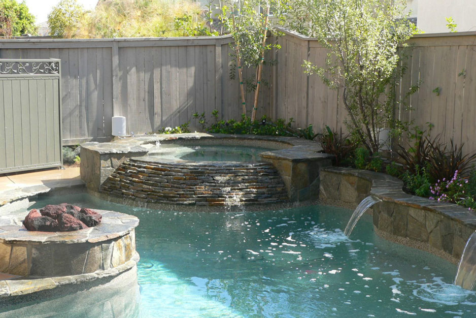 Inspiration for a mid-sized traditional backyard custom-shaped lap pool in Orange County with a hot tub and concrete slab.