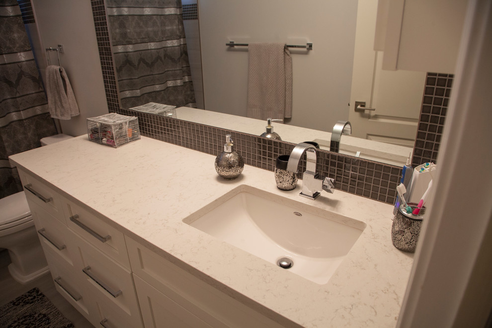 Large transitional master gray tile and glass sheet porcelain tile alcove bathtub photo in Edmonton with shaker cabinets, white cabinets, a two-piece toilet, gray walls, an undermount sink and quartz countertops