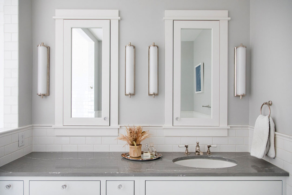 Inredning av ett amerikanskt stort grå grått en-suite badrum, med skåp i shakerstil, vita skåp, ett badkar med tassar, våtrum, en toalettstol med separat cisternkåpa, vit kakel, porslinskakel, vita väggar, klinkergolv i porslin, ett undermonterad handfat, vitt golv, med dusch som är öppen och bänkskiva i akrylsten