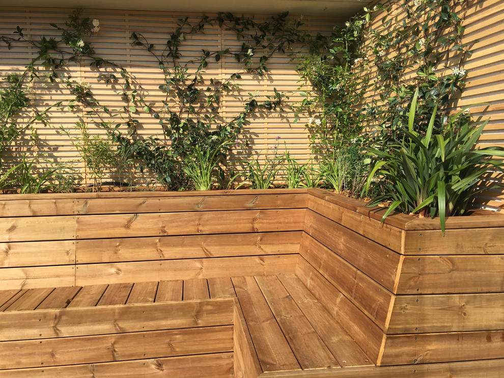 This is an example of a mid-sized modern patio in Paris with a container garden, concrete slab and no cover.
