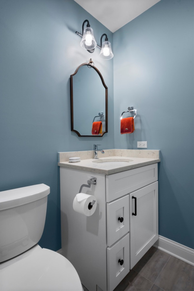 Mid-sized contemporary powder room in Chicago with shaker cabinets, white cabinets, a two-piece toilet, blue tile, porcelain tile, blue walls, porcelain floors, an undermount sink, engineered quartz benchtops, beige floor, beige benchtops and a freestanding vanity.