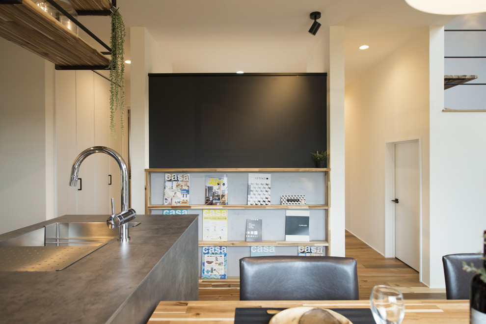 Industrial Lesezimmer mit schwarzer Wandfarbe, dunklem Holzboden, Einbau-Schreibtisch, braunem Boden, Tapetendecke und Tapetenwänden in Sonstige