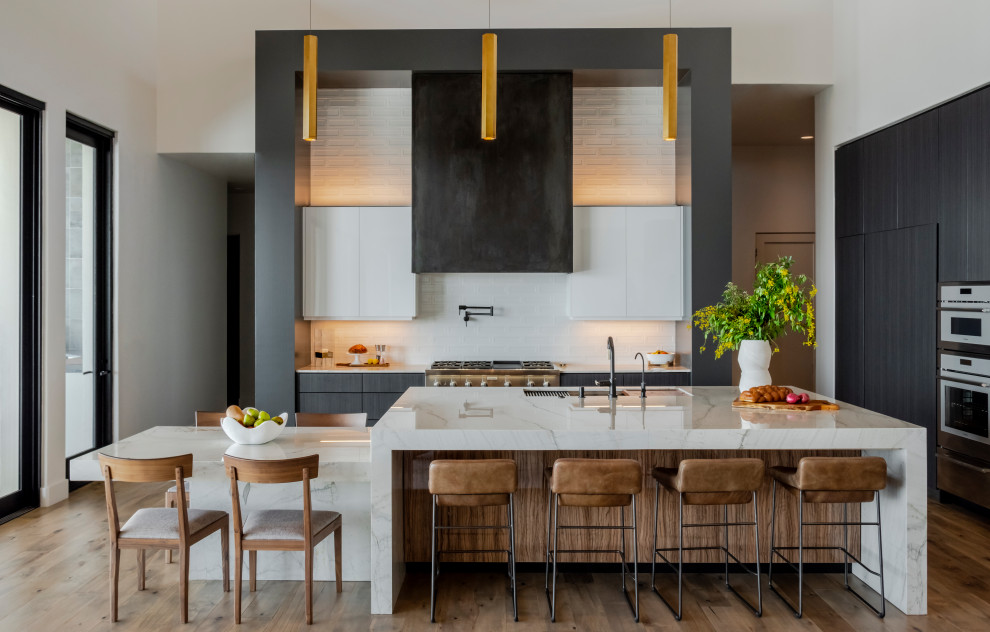 Moderne Küche mit Unterbauwaschbecken, flächenbündigen Schrankfronten, Elektrogeräten mit Frontblende und Kücheninsel in Austin