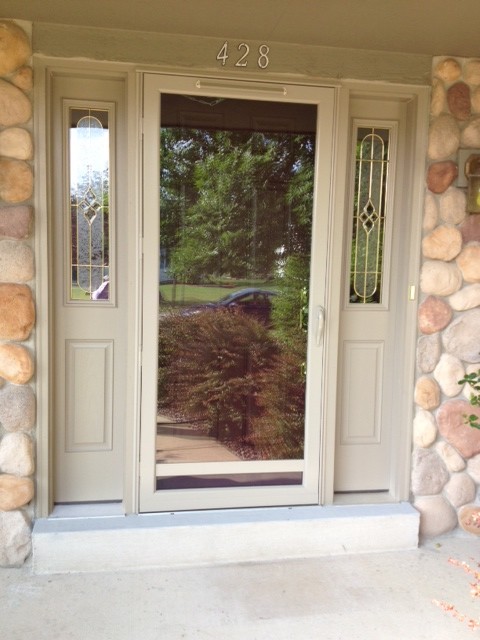 This is an example of a mid-sized traditional front door in Milwaukee with beige walls, linoleum floors, a single front door and a brown front door.