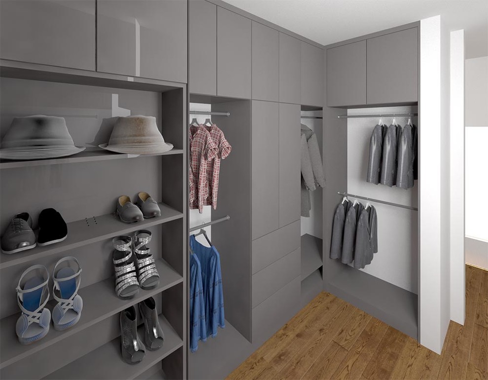 Modern gender-neutral walk-in wardrobe in Toronto with flat-panel cabinets, grey cabinets, laminate floors and brown floor.