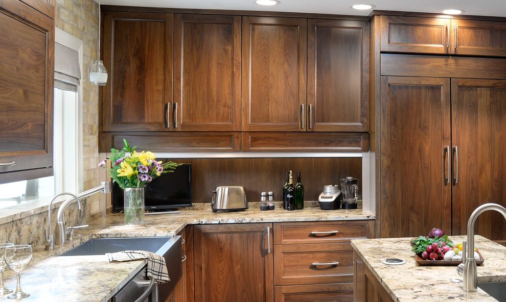 Example of a transitional u-shaped kitchen design in Indianapolis with granite countertops, an island, a farmhouse sink, flat-panel cabinets, dark wood cabinets, beige backsplash, stainless steel appliances and beige countertops