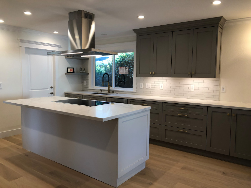 Example of a mid-sized transitional galley medium tone wood floor and beige floor eat-in kitchen design in San Francisco with an undermount sink, recessed-panel cabinets, gray cabinets, quartz countertops, white backsplash, ceramic backsplash, stainless steel appliances, an island and white countertops