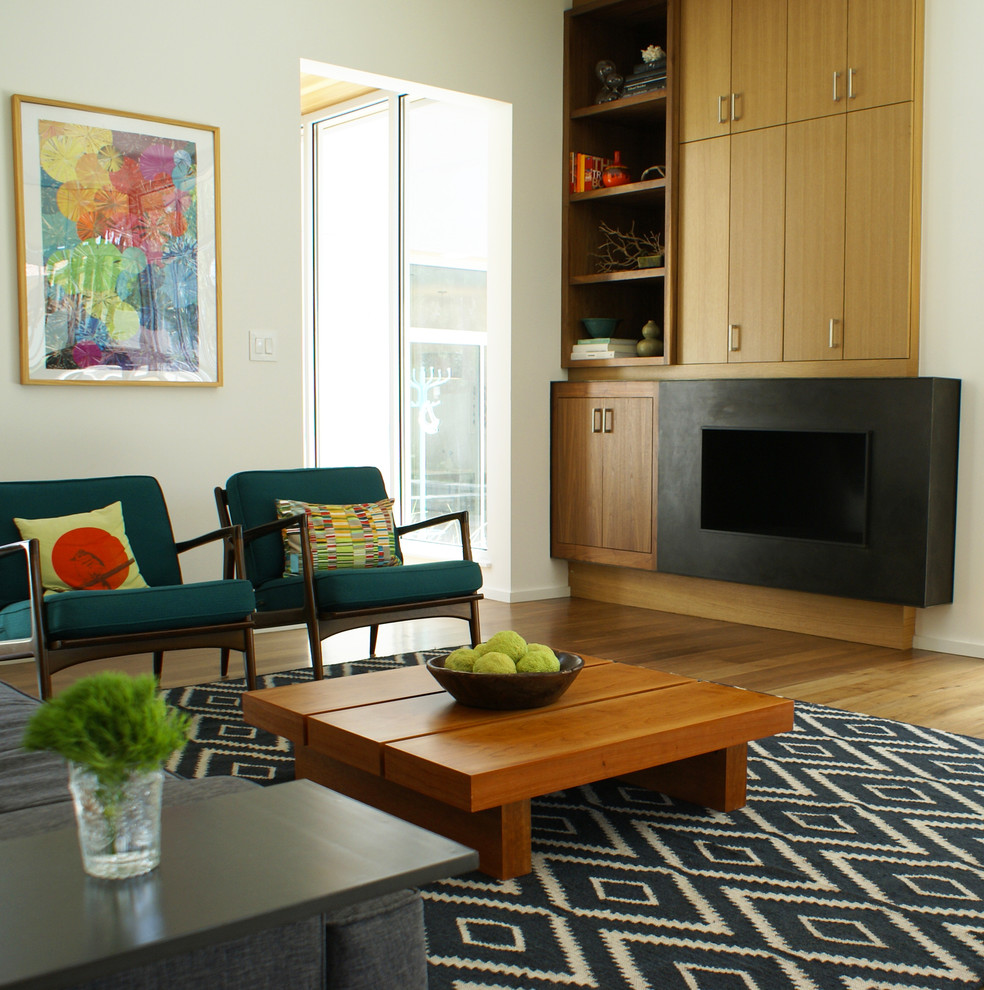 Modern living room in Austin with white walls and medium hardwood floors.