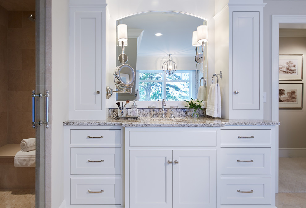 Inspiration for a large master bathroom in Minneapolis with recessed-panel cabinets, white cabinets, a drop-in tub, a two-piece toilet, beige walls, porcelain floors, an undermount sink and granite benchtops.