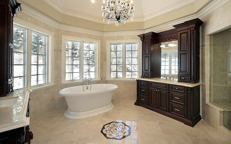This is an example of a large traditional master bathroom in Albuquerque with raised-panel cabinets, dark wood cabinets, a freestanding tub, an alcove shower, a two-piece toilet, beige walls, marble floors, an undermount sink and limestone benchtops.