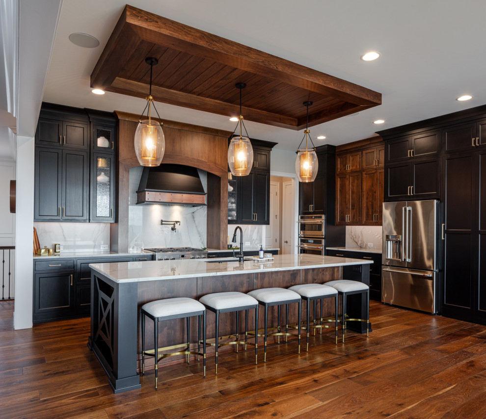 Kitchen - transitional l-shaped dark wood floor and brown floor kitchen idea in Cincinnati with an undermount sink, shaker cabinets, dark wood cabinets, white backsplash, stone slab backsplash, stainless steel appliances, an island and white countertops