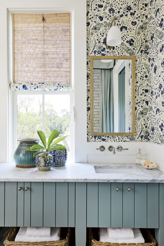 Design ideas for a beach style bathroom in Jacksonville with blue cabinets, multi-coloured walls, an undermount sink and white benchtops.