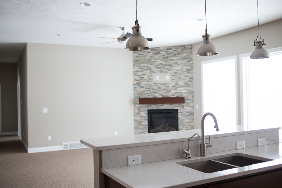 Inspiration for a mid-sized transitional l-shaped dark wood floor enclosed kitchen remodel with a double-bowl sink, shaker cabinets, dark wood cabinets, quartz countertops, gray backsplash, stone tile backsplash, stainless steel appliances and an island