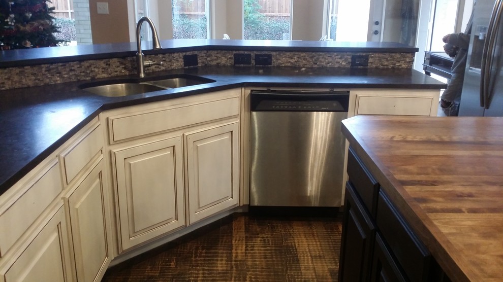 Inspiration for a large transitional brown floor open concept kitchen remodel in Dallas with an undermount sink, raised-panel cabinets, white cabinets, granite countertops, gray backsplash, stone tile backsplash, stainless steel appliances and an island