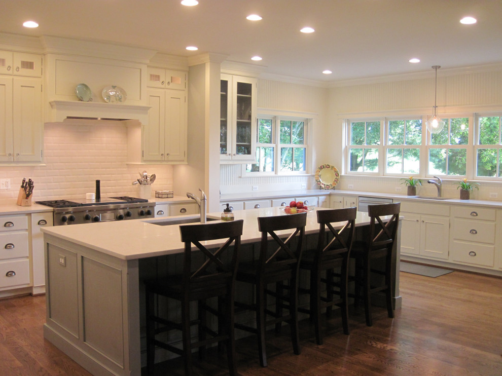 Inspiration for a large transitional u-shaped medium tone wood floor eat-in kitchen remodel in DC Metro with an undermount sink, shaker cabinets, green cabinets, quartz countertops, subway tile backsplash, an island and white countertops