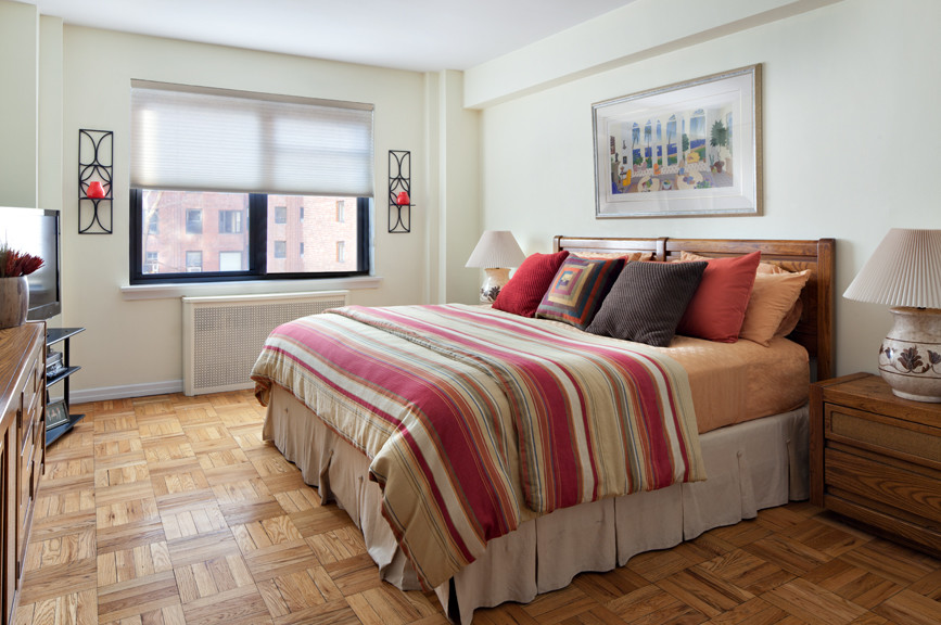 Inspiration for a mid-sized guest bedroom in New York with white walls, light hardwood floors and no fireplace.