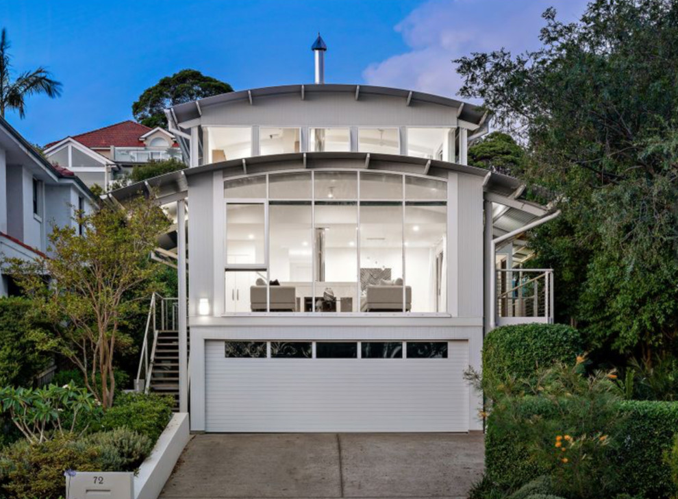 Inspiration for a small beach style three-storey white house exterior in Sydney with wood siding, a gable roof and a metal roof.