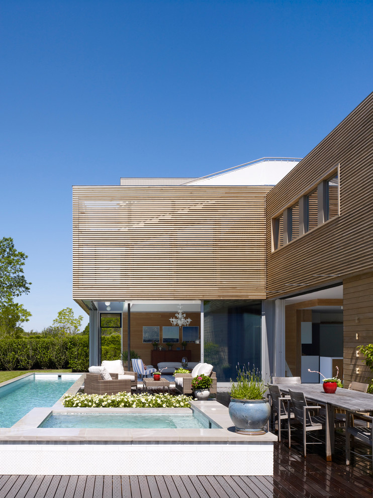 Photo of a contemporary two-storey exterior in New York with wood siding.